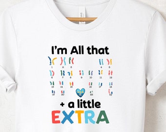 May include: White t-shirt with the text "I'm All that + a little EXTRA" in colourful letters. The text is surrounded by a pattern of colourful chromosome symbols.