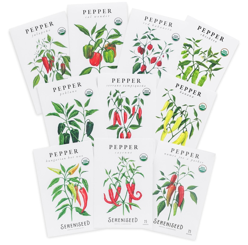 May include: A collection of white seed packets featuring watercolor illustrations of various pepper plants. Each packet displays the pepper type, such as 'Jalapeno' and 'Serrano Tampiqueno', along with the 'Sereniseed' logo and a USDA organic seal.