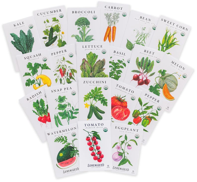 May include: A collection of seed packets featuring various organic vegetable varieties. Each packet displays a detailed illustration of the plant and its name, including kale, cucumber, broccoli, and tomato. The packets are arranged in a fan shape.