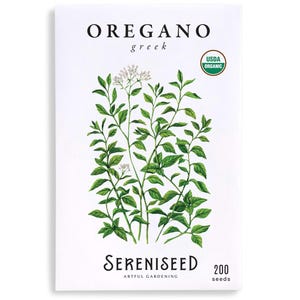 May include: A white seed packet with the words "OREGANO greek" at the top and "SERENISEED ARTFUL GARDENING" at the bottom. The packet features a watercolor illustration of oregano plants with green leaves and small white flowers. The USDA organic seal is visible.