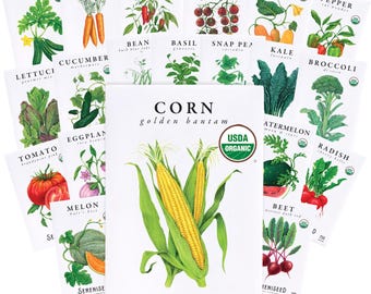 May include: A collection of white paper seed packets featuring botanical illustrations of various vegetables including corn, carrots, peppers, tomatoes, squash, lettuce, cucumbers, beans, basil, peas, kale, broccoli, eggplant, melons, watermelons, beets, and radishes.