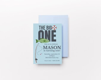 May include: A light blue birthday invitation with the text "THE BIG ONE" and a green fish illustration. The invitation includes details for Mason's first birthday, with a fishing theme. A light blue envelope is behind the invitation.