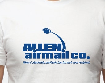 Puede incluir: Camiseta blanca con un logotipo azul que dice "ALLEN airmail co." y un gráfico de fútbol. El texto debajo del logotipo dice "When it absolutely, positively has to reach your recipient."