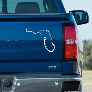 May include: A blue pickup truck with a white decal of the state of Florida shaped like a fishing hook on the back.
