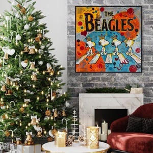 May include: A festive living room scene with a decorated Christmas tree, a framed artwork, and a red armchair. The artwork features Snoopy as The Beatles, with the text "The Beagles". The tree is adorned with lights, ornaments, and bells.