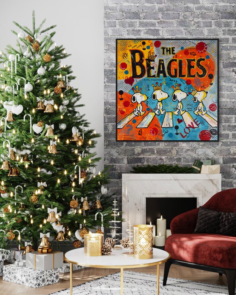 May include: A festive living room scene with a decorated Christmas tree, a framed artwork, and a red armchair. The artwork features Snoopy as The Beatles, with the text "The Beagles". The tree is adorned with lights, ornaments, and bells.