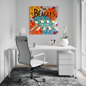 May include: A colorful pop art painting titled "The Beagles" depicts Snoopy and his friends crossing a street, a parody of the Beatles' Abbey Road album cover. The artwork features vibrant orange, blue, and yellow hues.