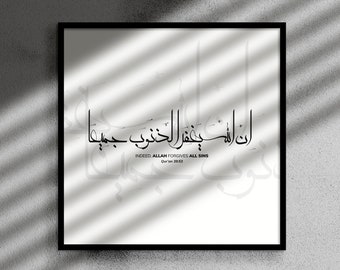 May include: Black framed art print with Arabic calligraphy on a white background. The text reads "INDEED ALLAH FORGIVES ALL SINS" in elegant script. The artwork is set against a textured gray wall with shadows.