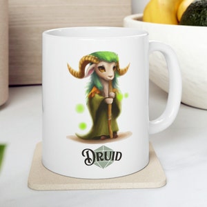 May include: White ceramic mug featuring a green and brown cartoon ram with horns, wearing a green robe and holding a staff. The mug has the word "DRUID" printed on it.