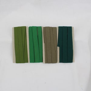 May include: Four different colours of fabric ribbon, from left to right: olive green, green, khaki, and dark green.