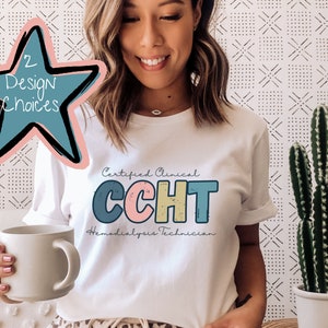 Puede incluir: Camiseta blanca con el texto "Certified Clinical CCHT Hemodialysis Technician" en letras de bloque de colores.