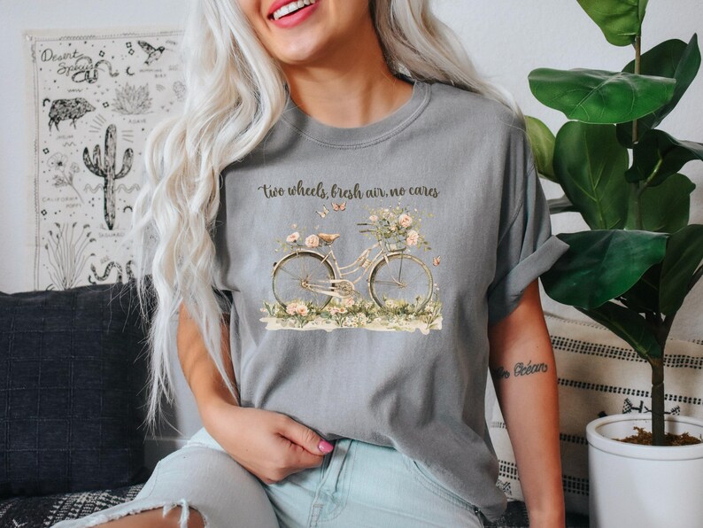 May include: A gray t-shirt with a vintage bicycle graphic and the text "Two wheels, fresh air, no cares".