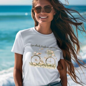 May include: White t-shirt with a floral bicycle graphic and the text "Two wheels, fresh air, no cares".