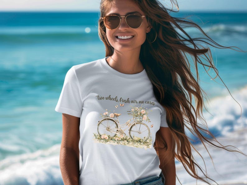 May include: White t-shirt with a floral bicycle graphic and the text "Two wheels, fresh air, no cares".