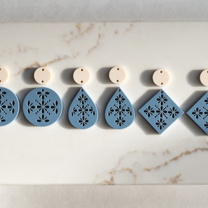 May include: Six pairs of earrings with a blue and white floral design. The earrings are made of acrylic and have a delicate, intricate pattern. The earrings are available in a variety of shapes, including circles, teardrops, and squares.