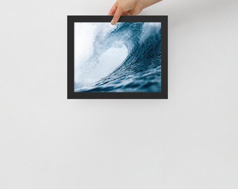 Könnte beinhalten: Ein gerahmtes Foto einer großen, blauen Ozeanwelle, die bricht und sich über sich selbst rollt. Die Welle wird von der Sonne beleuchtet, wodurch ein heller weißer Bereich in der Mitte der Welle entsteht.