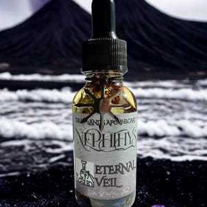 May include: A clear glass bottle with a black dropper and a silver star-shaped charm. The label reads "Nephthys Eternal Veil." The background features a dark mountain range and ocean waves. A purple flower is in the foreground.