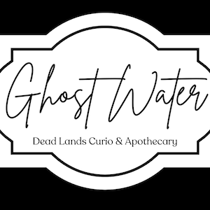 May include: A white rectangular label with rounded, decorative edges and a black border. The text Ghost Water is written in a black cursive script, with the text Dead Lands Curio & Apothecary printed in a smaller, simple black serif font below.