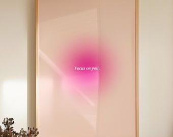 Può includere: Una stampa incorniciata con uno sfondo sfumato rosa e il testo "Focus on you." in bianco. La stampa è appesa a una parete bianca sopra un bancone con una ciotola di limoni e bottiglie decorative.
