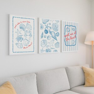 May include: Three framed art prints with a beach theme. Each print features blue illustrations of seashells, starfish, and marine life on a white background. One print has text that says "meet me at the beach".