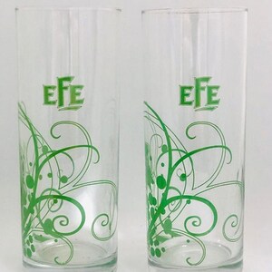 Puede incluir: Dos vasos de beber de vidrio transparente con un diseño de espiral verde y la palabra "EFE" impresa en la parte delantera.