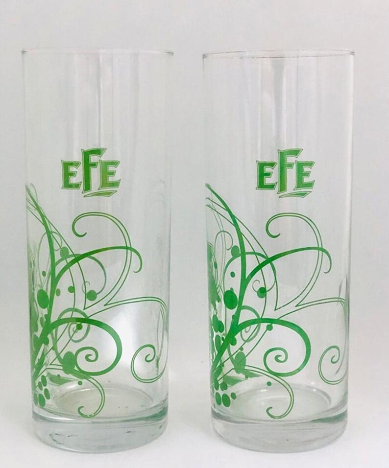 May include: Two clear glass drinking glasses with a green swirl design and the word "EFE" printed on the front.