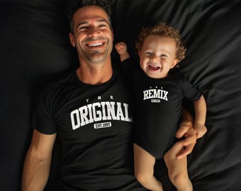 May include: A father and son wearing matching black t-shirts. The father's shirt says "The Original Est. 1997" and the son's shirt says "The Remix Est. 2021".