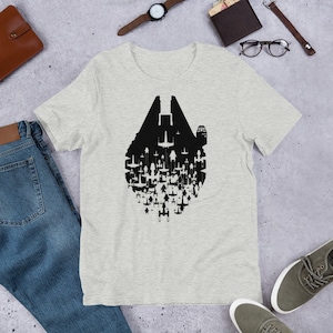 Puede incluir: Una camiseta gris jaspeada con una silueta negra de un Destructor Estelar formado por cazas X-Wing.