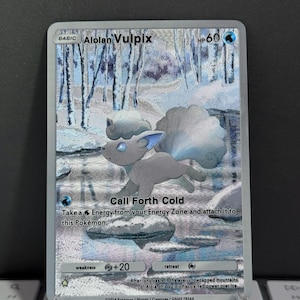 May include: A Pokémon trading card featuring Alolan Vulpix. The card has a snowy background with the text "Call Forth Cold." The card's HP is 60. The card also has the text "weakness +20" and "retreat."