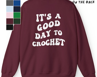 Puede incluir: Sudadera color burdeos con texto blanco en la espalda que dice "Es un buen día para tejer a crochet."