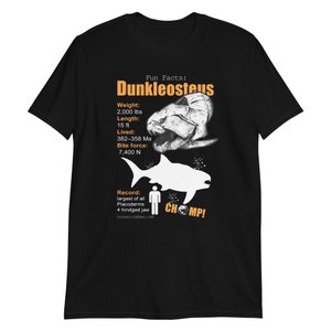 May include: Black t-shirt featuring an orange graphic of a Dunkleosteus, an extinct armoured fish, with facts about its size, weight, bite force, and time period. The text "Fun Facts: Dunkleosteus" and "CHOMP!" are also included in the graphic.