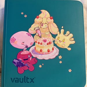 K&ouml;nnte beinhalten: Ein blaugr&uuml;ner Ordner mit einer grafischen Illustration von vier Zeichentrickfiguren, die eine Erdbeertorte verzieren. Die Figuren umfassen ein gelbes Wesen mit einem Spritzbeutel, ein rosa rundes Wesen, ein rotes Wesen und einen gelben Klecks. Der Text vaultx ist unten links aufgedruckt.
