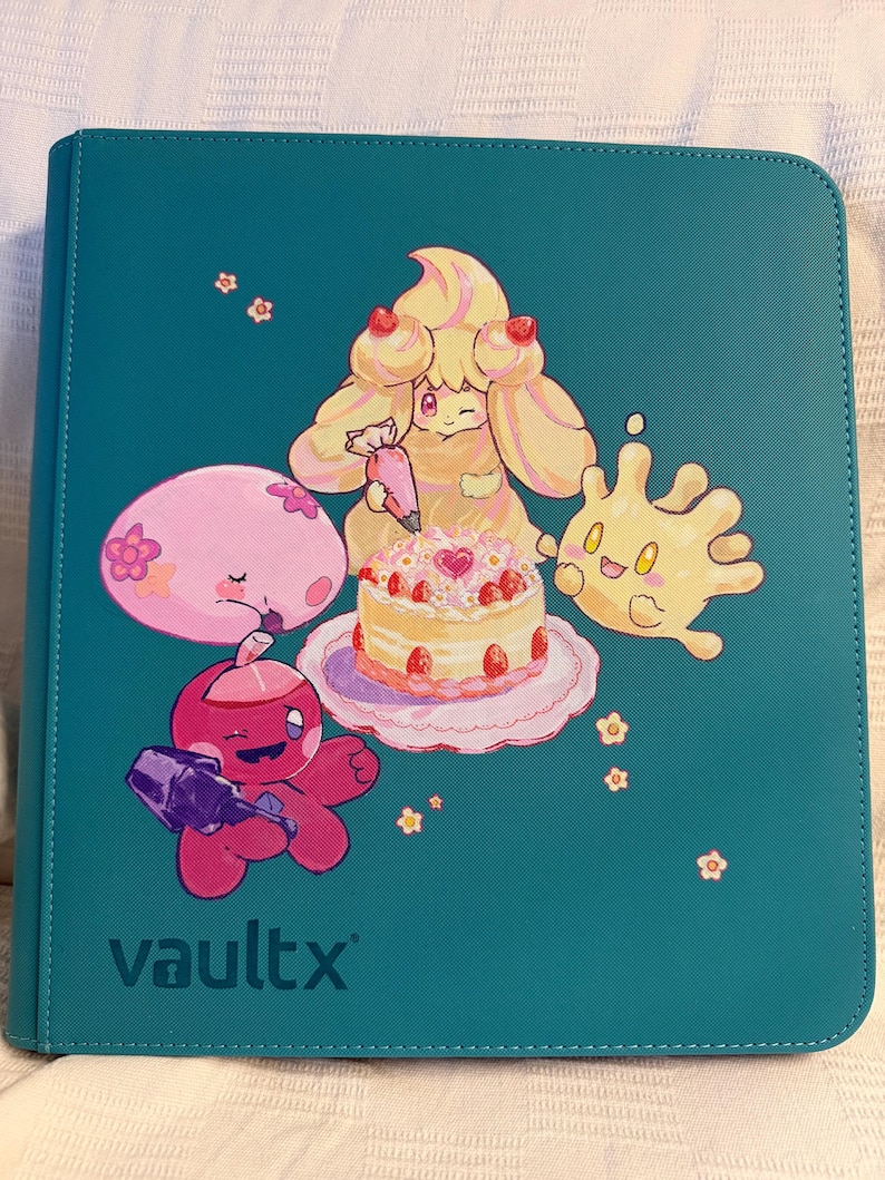 K&ouml;nnte beinhalten: Ein blaugr&uuml;ner Ordner mit einer grafischen Illustration von vier Zeichentrickfiguren, die eine Erdbeertorte verzieren. Die Figuren umfassen ein gelbes Wesen mit einem Spritzbeutel, ein rosa rundes Wesen, ein rotes Wesen und einen gelben Klecks. Der Text vaultx ist unten links aufgedruckt.
