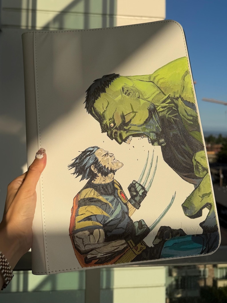 K&ouml;nnte beinhalten: Eine wei&szlig;e, rechteckige Dokumentenmappe mit einer detaillierten Comic-Illustration, die den gr&uuml;nen Hulk zeigt, wie er den gelb-blauen Wolverine anbr&uuml;llt, welcher seine metallischen Krallen aus den H&auml;nden ausgefahren hat.