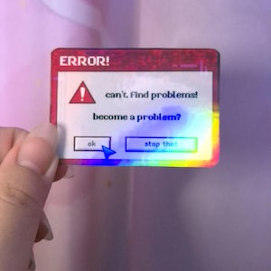 Könnte beinhalten: Ein holografischer Aufkleber mit rotem Rand und dem Wort "ERROR!" oben. Der Aufkleber zeigt ein Warnsymbol und den Text "can't find problems! become a problem?" mit den Schaltflächen "ok" und "stop that".