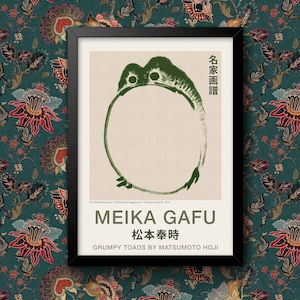 Peut inclure: Une estampe encadrée d'une peinture japonaise représentant un crapaud vert avec le titre "Meika Gafu" et le texte "松本奉時" (Matsumoto Hoji) en japonais. Le texte "Grumpy Toads by Matsumoto Hoji" est également inclus.
