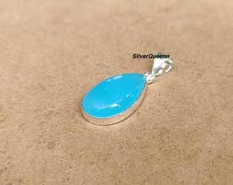 May include: A teardrop-shaped pendant with a light blue gemstone set in silver.