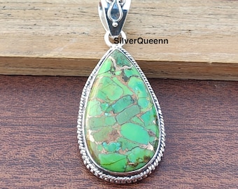 May include: A teardrop-shaped pendant with a green and gold turquoise stone set in sterling silver. The pendant has a detailed silver bail.