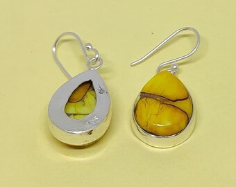 May include: A pair of silver teardrop earrings. Each earring has a bright yellow stone with brown veining, set in a polished silver bezel. The earrings have a classic hook design.