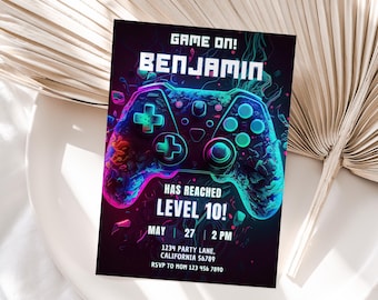 May include: A neon blue and purple video game controller with the text "GAME ON! BENJAMIN HAS REACHED LEVEL 10!" and party details for a birthday party.