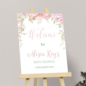 Peut inclure: Une pancarte d'accueil blanche avec une bordure florale rose et le texte "Bienvenue à la Baby Shower d'Alisia Key's 28 mars 2025".