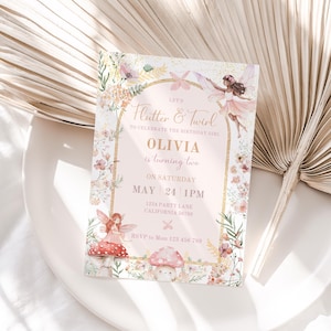 May include: A rectangular birthday invitation card featuring a gold-arched frame, watercolour illustrations of fairies, mushrooms, and wildflowers. The text reads: Let's Flutter & Twirl to celebrate the birthday girl OLIVIA is turning two on Saturday May 24 1PM.