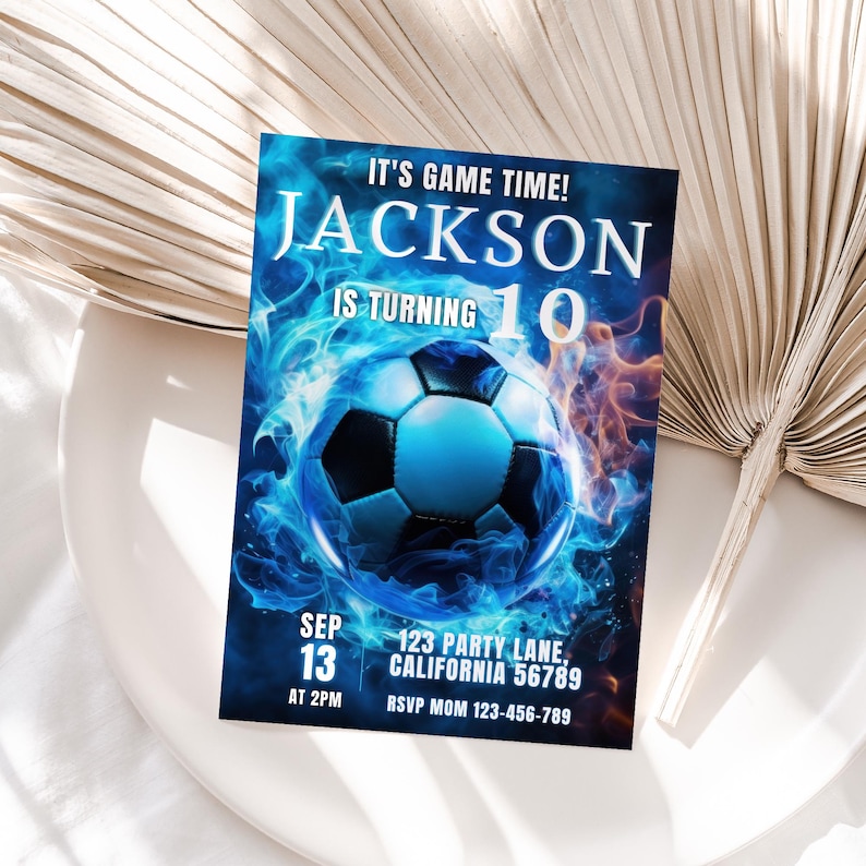 May include: A blue and orange birthday invitation with a soccer ball in flames. The invitation says "It's game time! Jackson is turning 10".