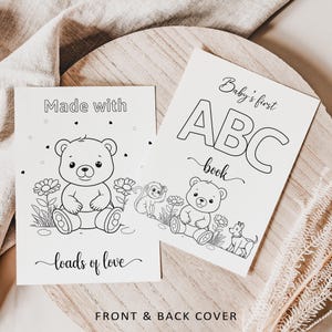 May include: Two black and white baby books with illustrations of a teddy bear, monkey, and dog. One book reads "Made with loads of love" and the other says "Baby's first ABC book". The words "Front & Back Cover" are at the bottom.