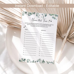 以下が含まれることがあります： 白い背景と緑色のユーカリの葉がついた、印刷可能な「名前を付けてください」ゲームカード。カードにはタイトル、説明、そしてAからLまでのアルファベットのリストがあり、曲名とアーティストの名前を書くための空白の行があります。