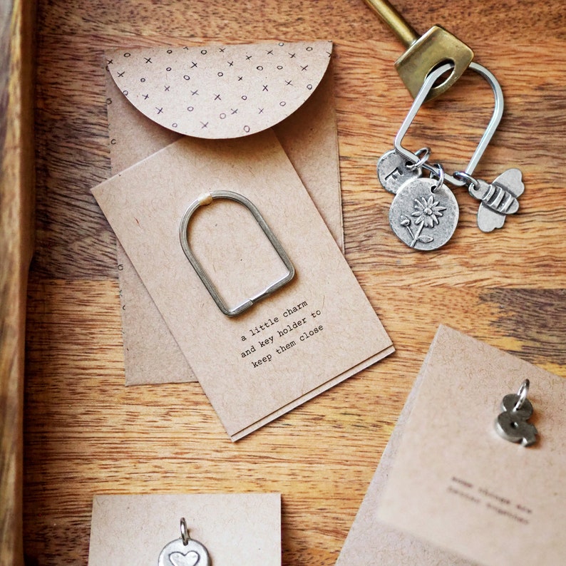 Peut inclure: Un petit charme en m&eacute;tal et un porte-cl&eacute;s avec le texte "un petit charme et un porte-cl&eacute;s pour les garder pr&egrave;s de vous".