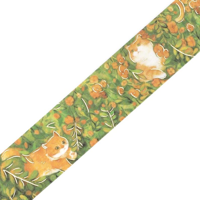 May include: Decorative washi tape featuring a repeating pattern of orange and white cats lounging in a green garden with orange flowers and white leaves. The tape is angled diagonally across a white background.