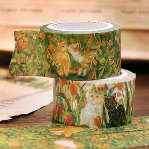 May include: Two rolls of decorative washi tape. The top roll features a green background with orange flowers and gold-outlined cats. The bottom roll has a similar design with white and black cats. The tape is ideal for scrapbooking and crafts.