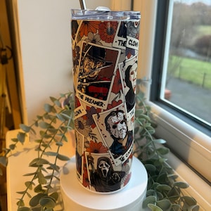 May include: A stainless steel tumbler with a floral and horror movie character design. The tumbler features images of Freddy Krueger, Jason Voorhees, and Ghostface, with the words "The Preamer" and "The Clown". Includes a silver straw.