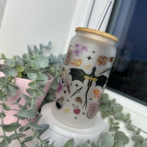 K&ouml;nnte beinhalten: Ein mattierter Glasbecher mit einem schwarzen Drachen, Sternen und anderen magischen Bildern. Der Becher hat einen Bambusdeckel und einen durchsichtigen Trinkhalm. Der Text auf dem Becher lautet "Dragon Mom Coffee"